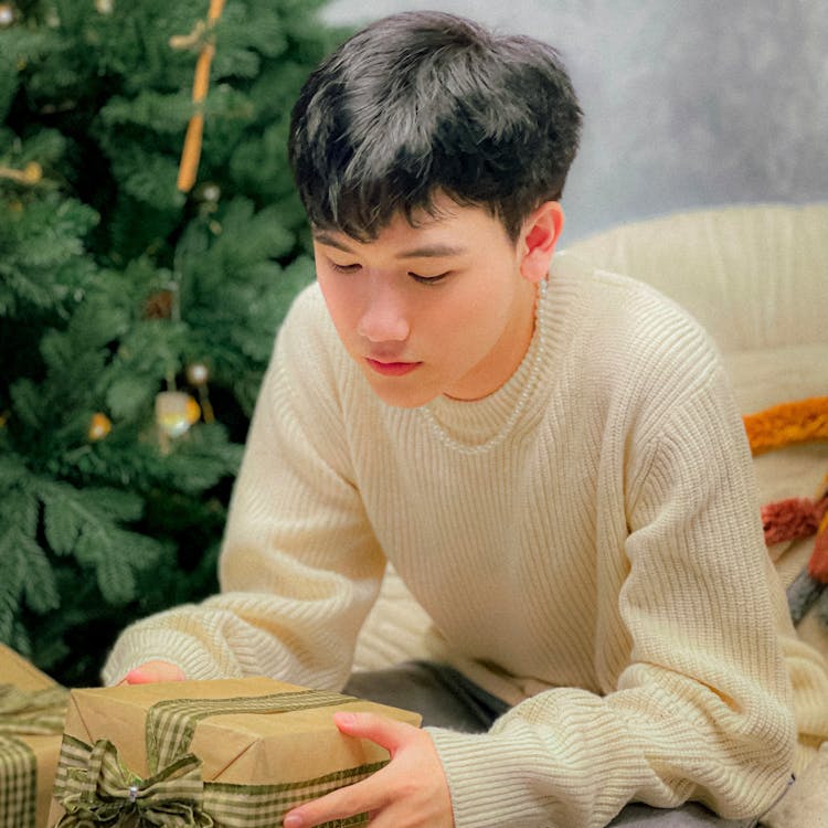 Boy Wearing Sweater Holding A Gift