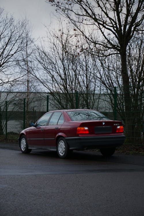 Red Car Parked Near Green Fence