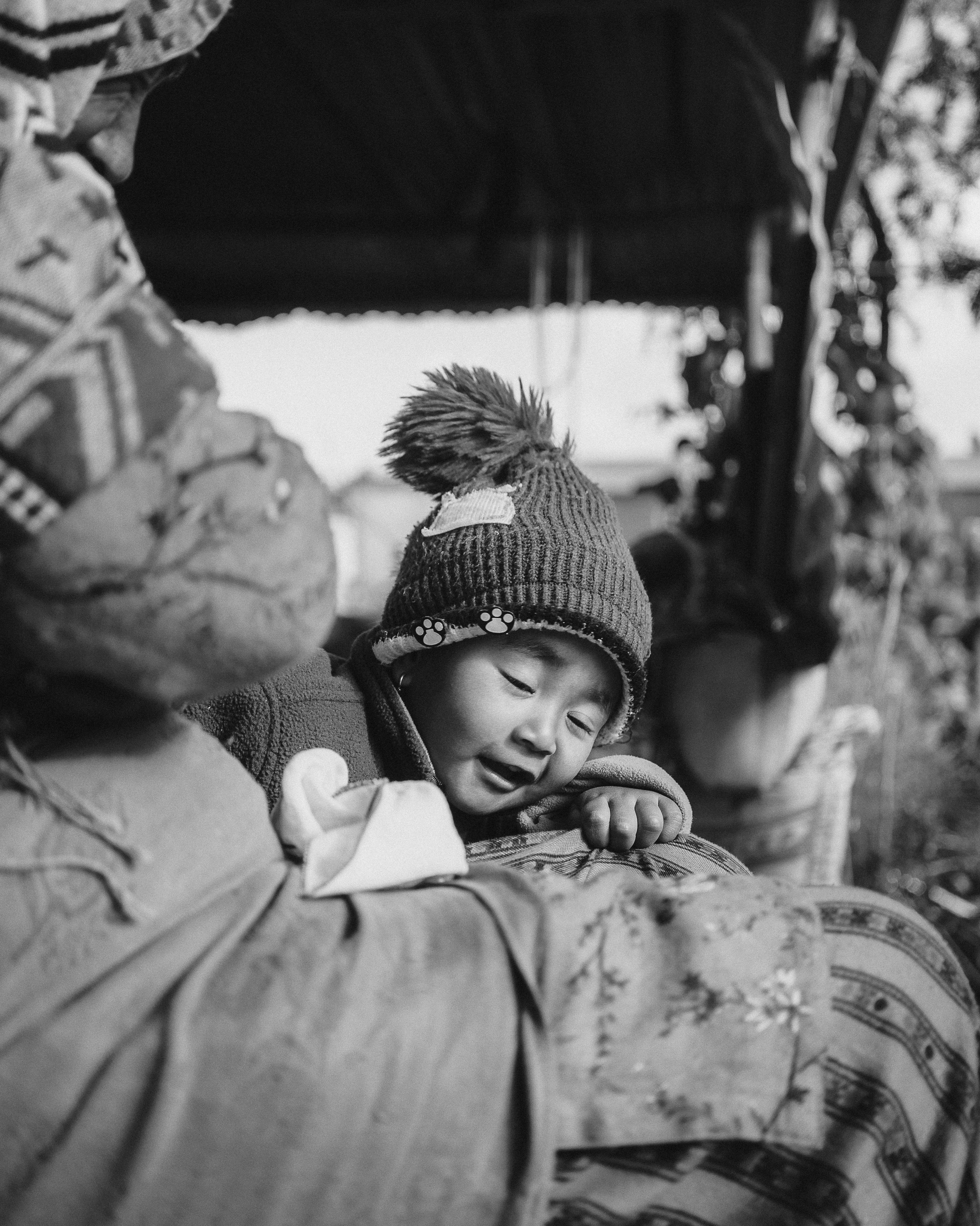 Heartwarming black and white portrait of a child and grandmother in an outdoor setting.