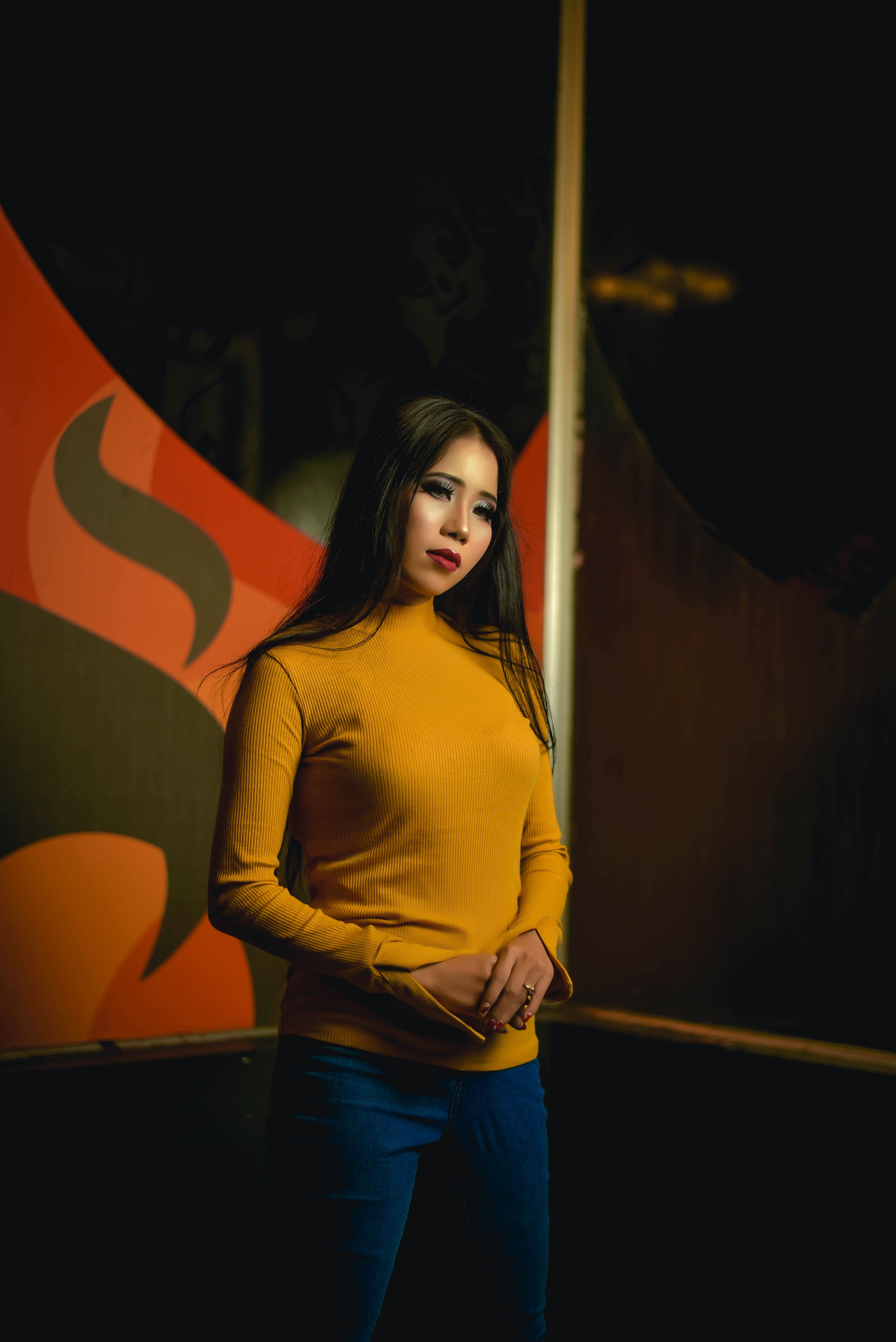 A Woman in Yellow Long Sleeve Shirt and Blue Denim Jeans · Free Stock Photo