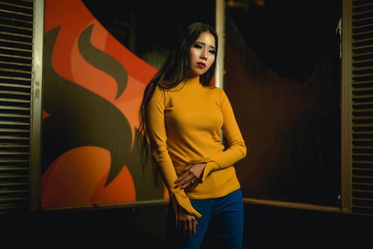 Elegant portrait of a woman in a yellow sweater against a bold graphic background. Perfect for fashion or lifestyle themes.