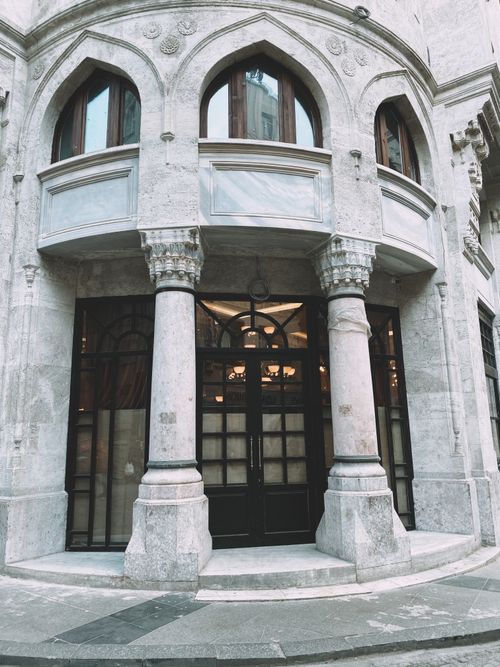 Free Classic architectural facade featuring arched windows and stone columns, exuding elegance. Stock Photo