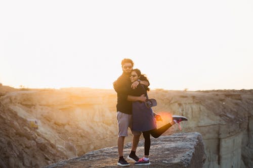 A Couple Hugging Each Other while Standing Near the Cliff