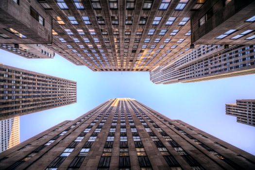 Low angle view of New York City skyscrapers against a clear blue sky.
