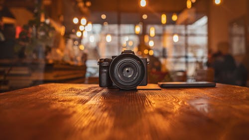 Free Black DSLR on Wooden Table Top  Stock Photo