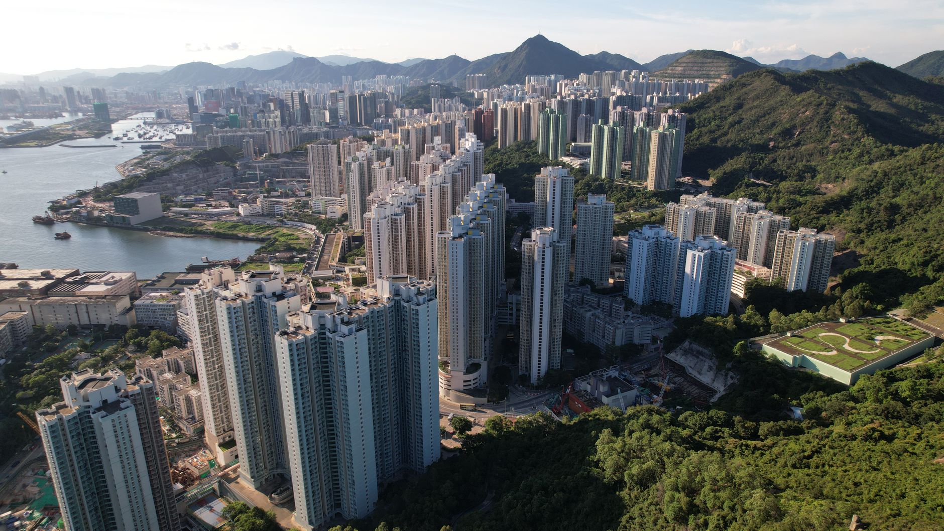 Stunning aerial view of Kowloon's urban skyline showcasing towering skyscrapers and lush greenery in Hong Kong.