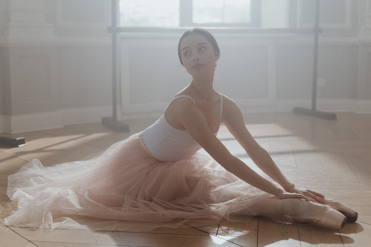 A Ballerina Sitting On The Floor