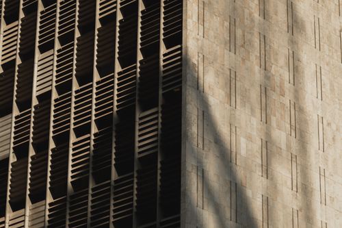 Free Low angle shot of a modern concrete building exterior with intricate design and shadows. Stock Photo