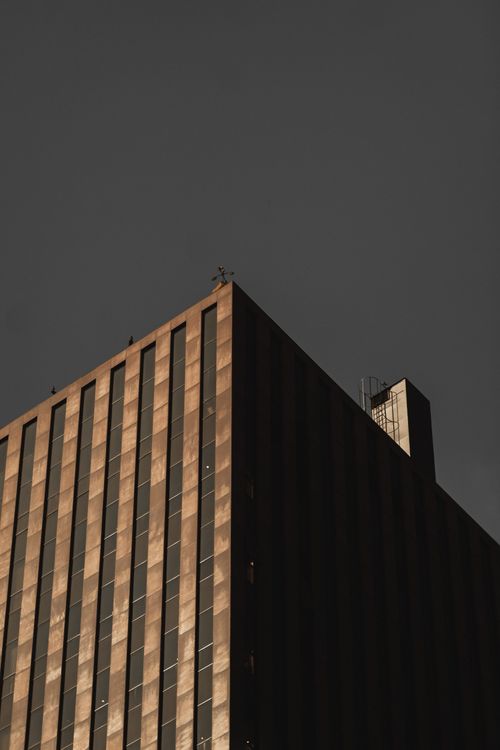 Free Low-angle shot of a modern high-rise building with a gray sky backdrop. Stock Photo