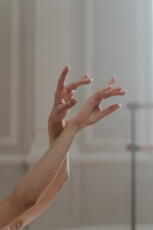 A Ballerina Dancing and Raising her Hands