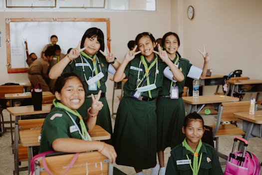 A group of joyful girl scouts posing happily in an elementary school classroom environment.