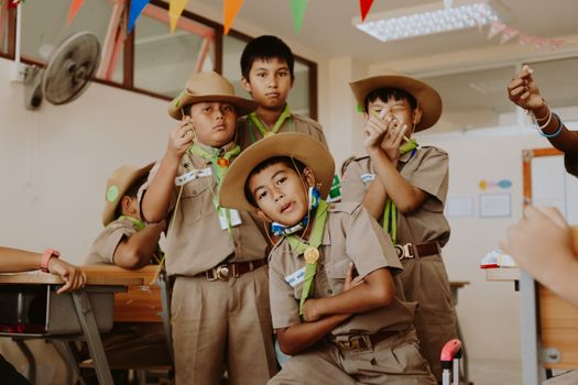 Group of young boy scouts in uniform enjoying activities indoors with enthusiasm and teamwork.