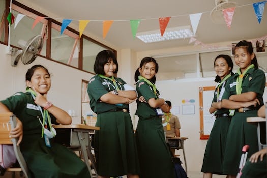 Young students in green school uniforms pose confidently in a colorful classroom setting.