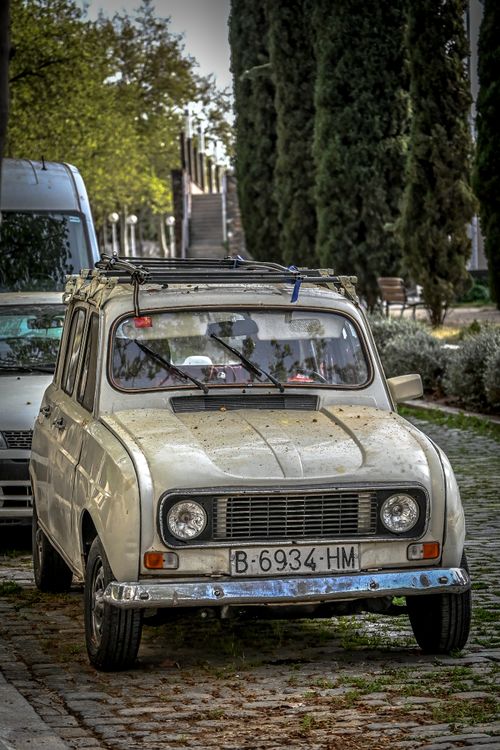 Free A classic vintage car parked on cobblestone streets in Barcelona, displaying charm and nostalgia. Stock Photo