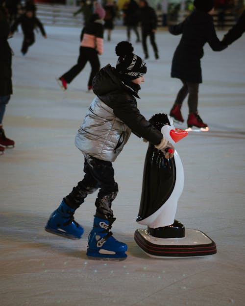 Man in Black Jacket and White Pants Riding on Black Skateboard