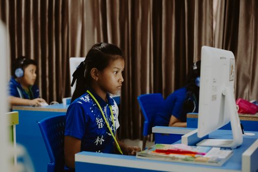Young girls focused on learning in a computer lab, showcasing modern education.