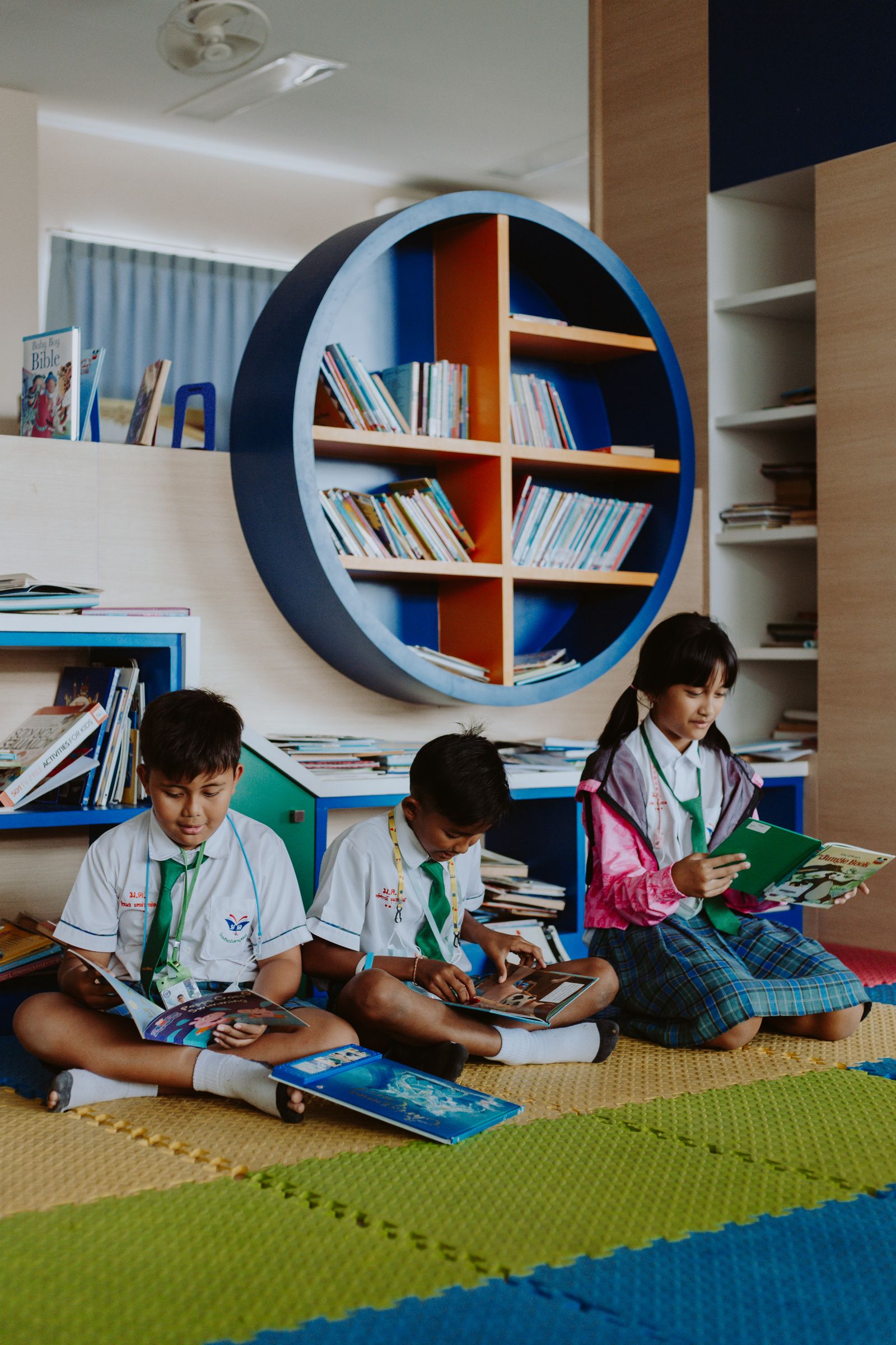 Children reading books in a bright school library