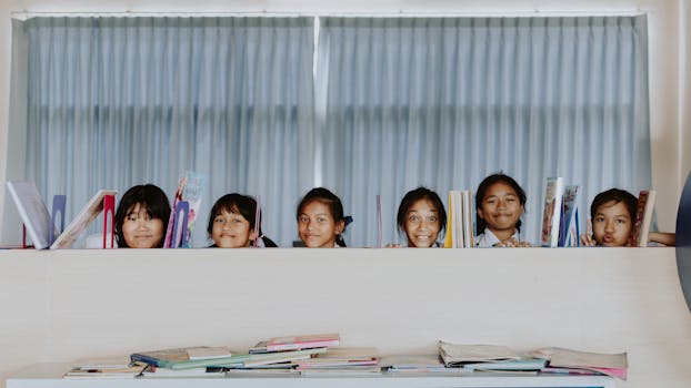 Group of smiling children having fun in a library setting with books.