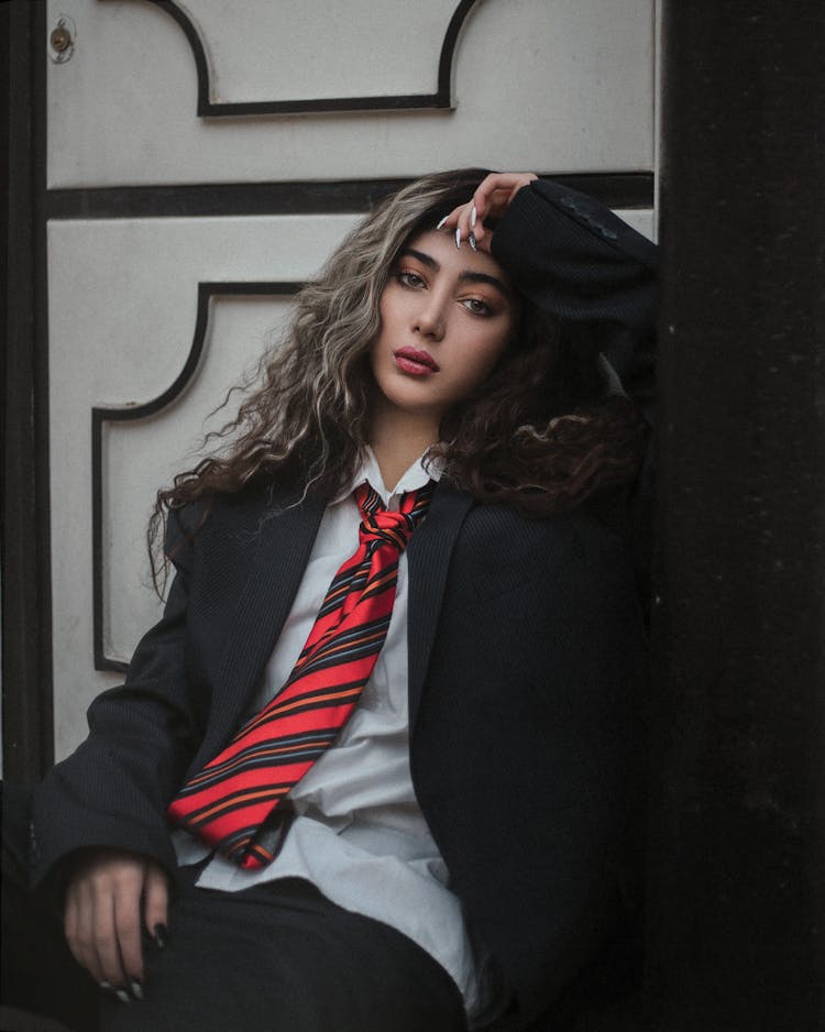 A Girl In Black Blazer And Red Striped Necktie