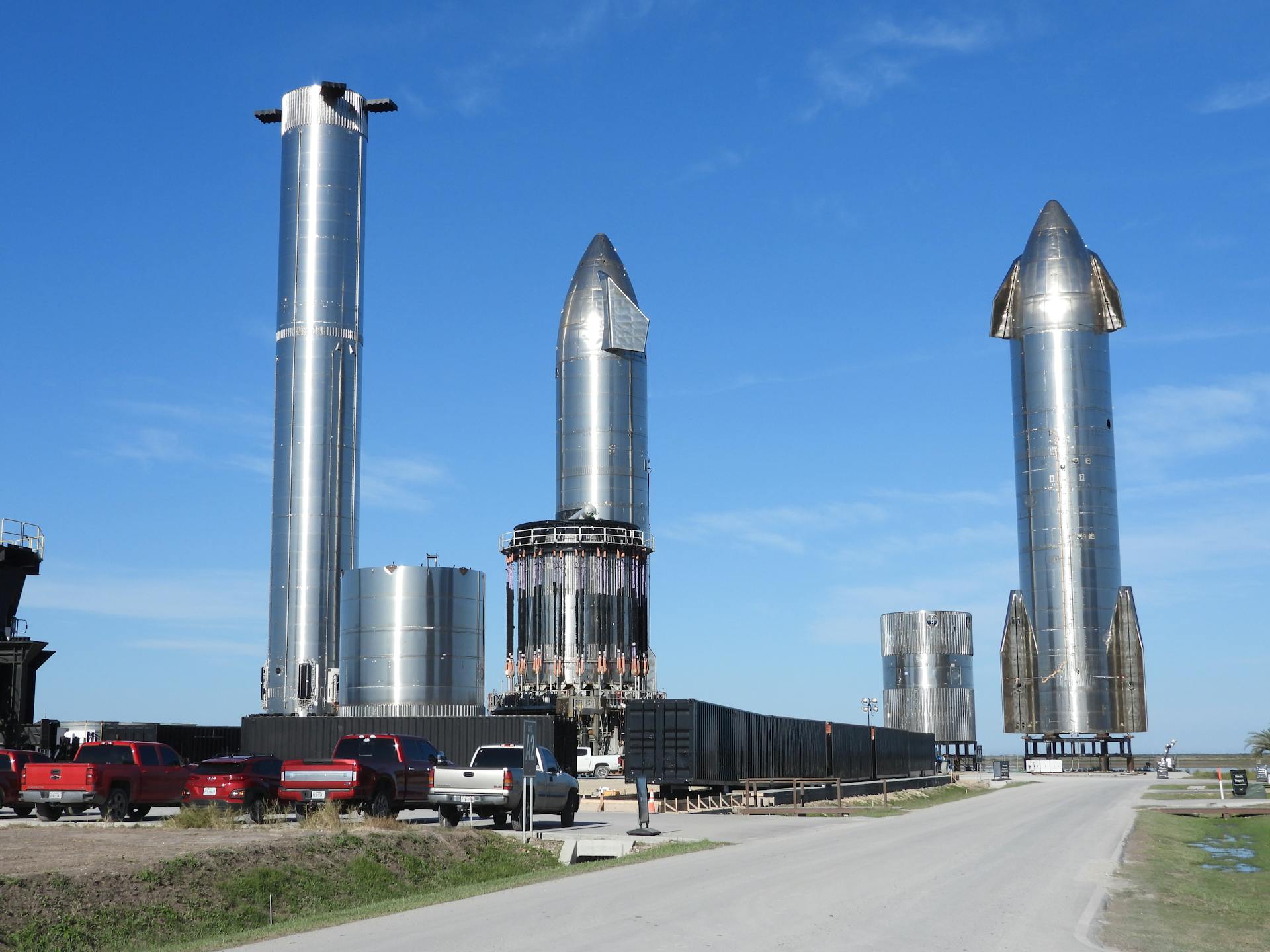 Starship prototypes standing tall at Brownsville, Texas launch site under clear skies.