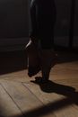 Person in Black Shorts and Brown Shoes Standing on Brown Wooden Floor