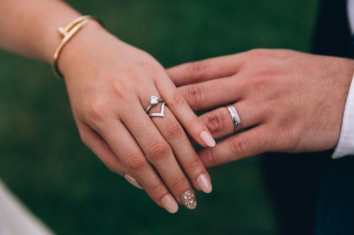 Free Intimate close-up of a couple's hands showcasing engagement and wedding rings. Stock Photo
