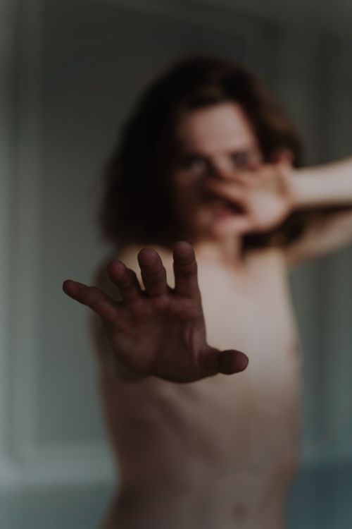 Free An evocative image of a shirtless person with blurred focus, reaching out dramatically. Stock Photo