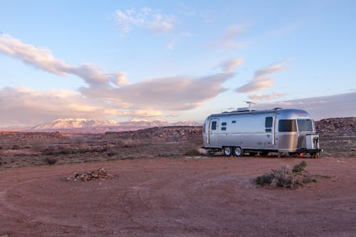 Free Grey and Black Recreational Vehicle on Ground Under Blue and White Sky Stock Photo