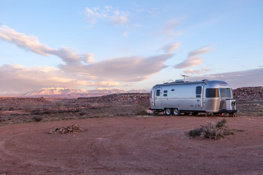 Silver Desert Star travel trailer on red desert ground at sunset