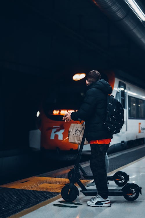 A Man with a Scooter Waiting for the Train