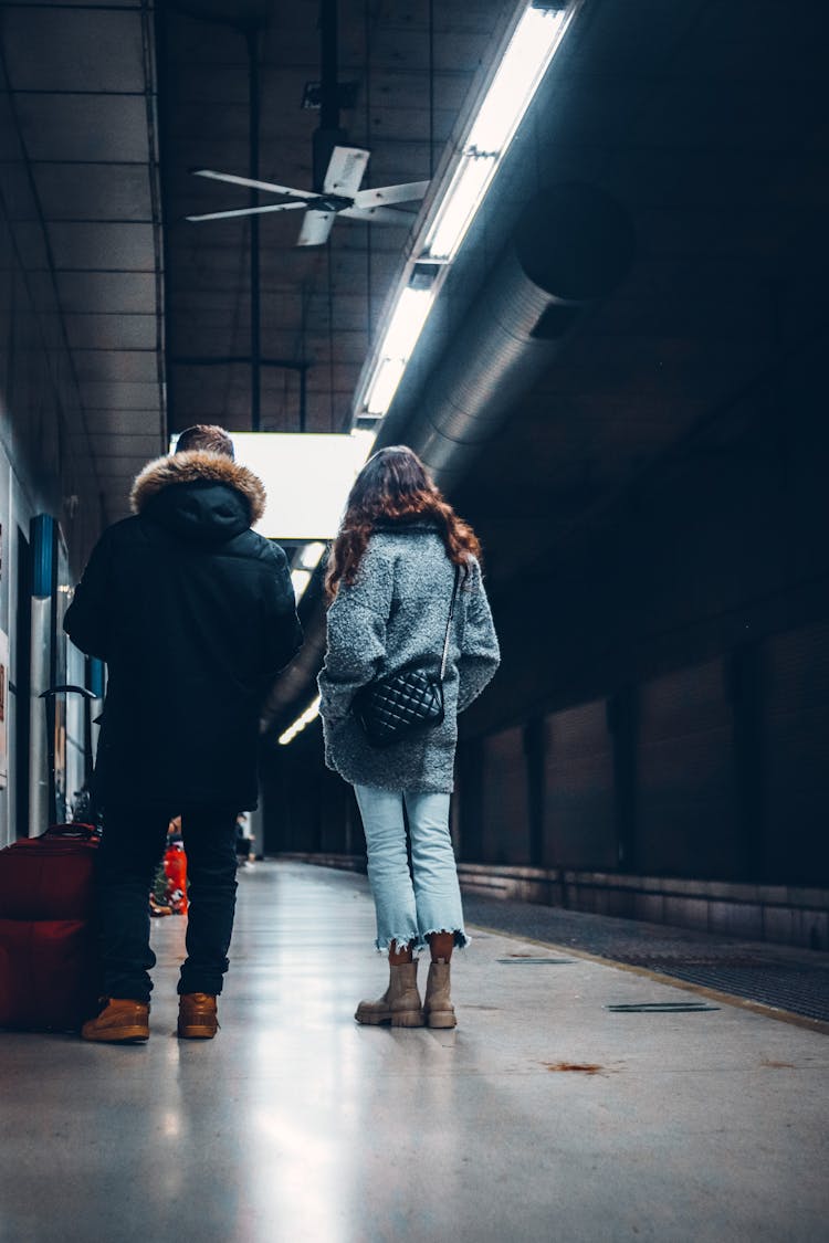 Back View Of A Man And A Woman Standing On A Subway Station