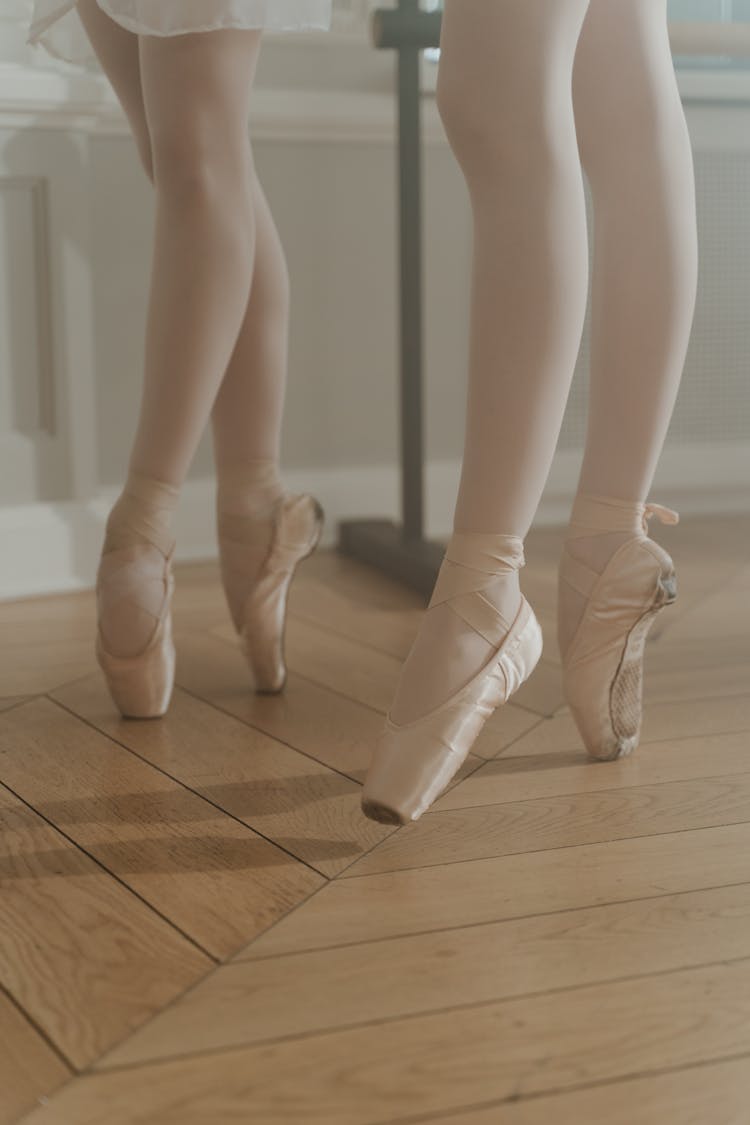 Ballerinas In Pointed Shoes Standing On The Wooden Floor