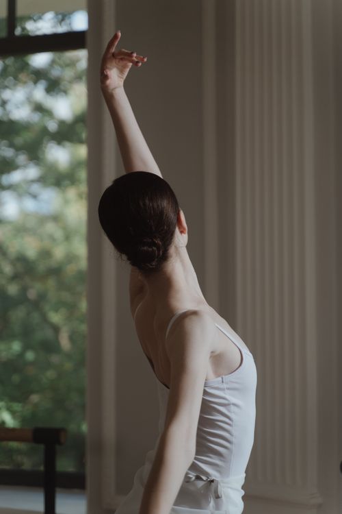 Free Elegant ballerina performing a graceful posture in a dance studio. Stock Photo