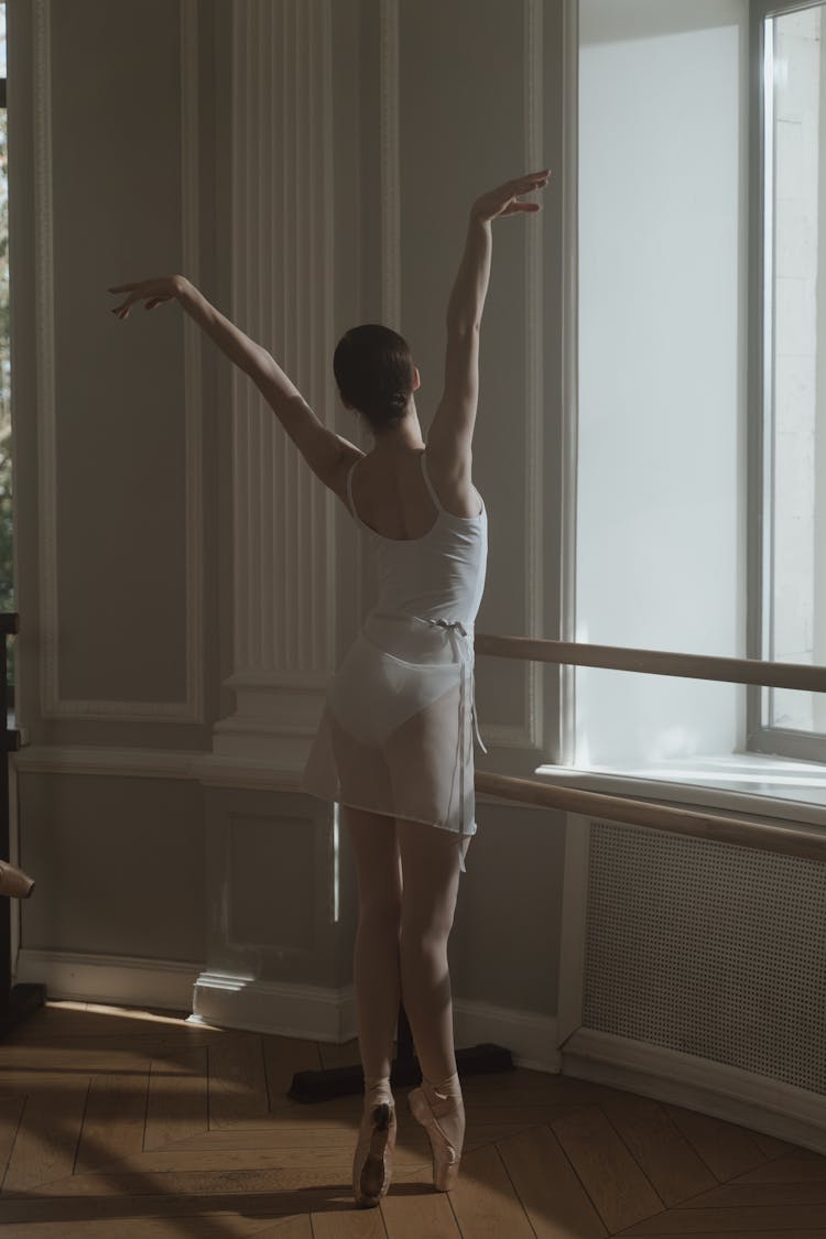 Woman In White Leotard And Pointe Shoes Dancing