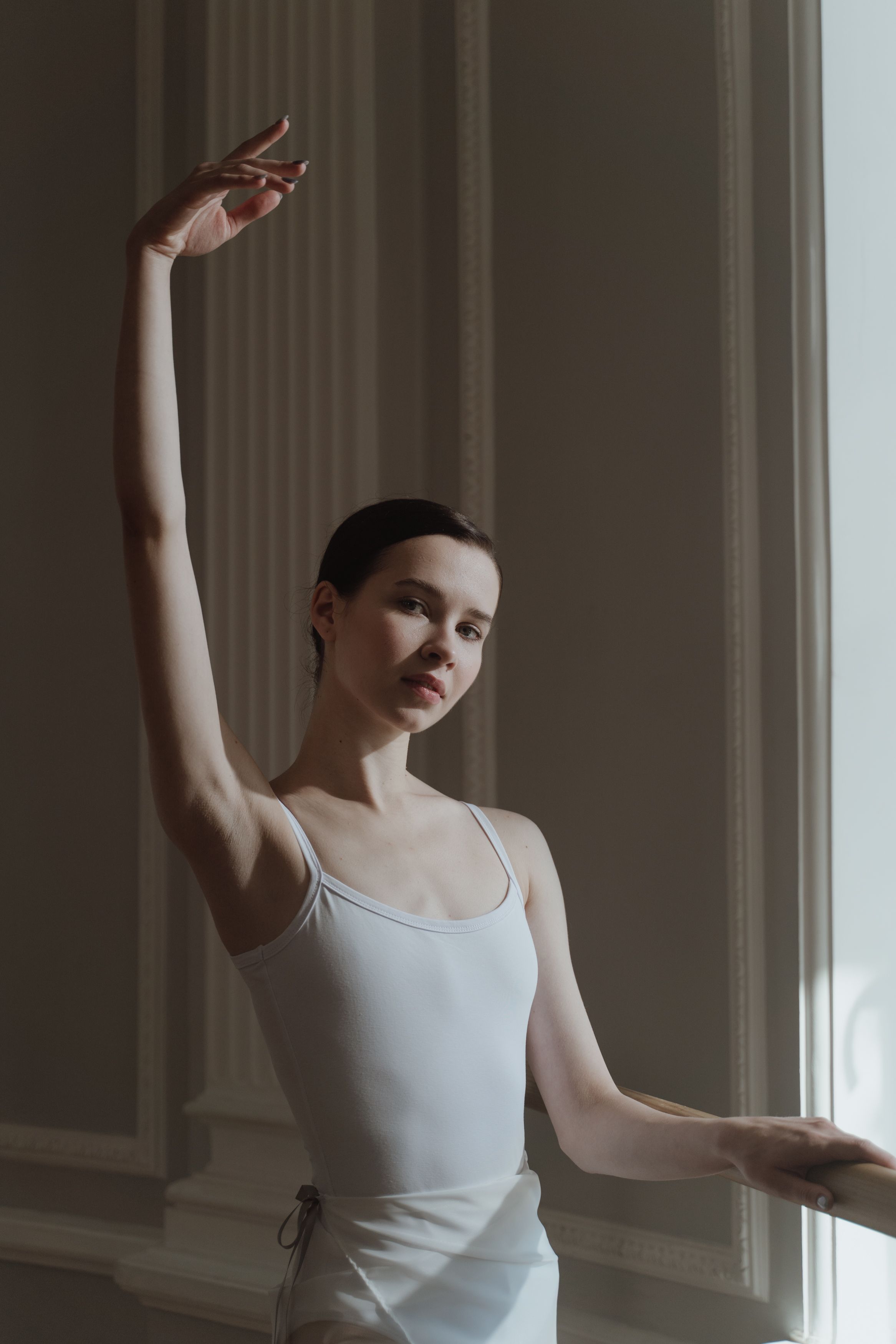 Elegant ballerina striking a pose in a beautifully lit ballet studio, exuding grace and poise.