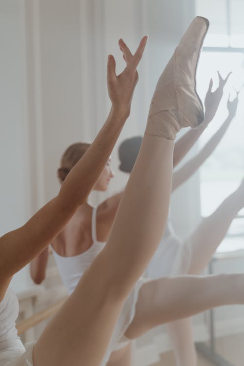 Free Ballet Dancers Extending Arm and Leg Up Stock Photo