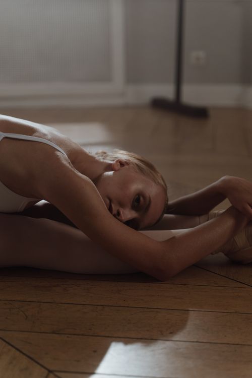 Free A graceful ballerina in a serene dance studio stretching her body with elegance. Stock Photo