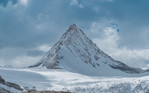 Snow Covered Mountain Under the Cloudy Sky