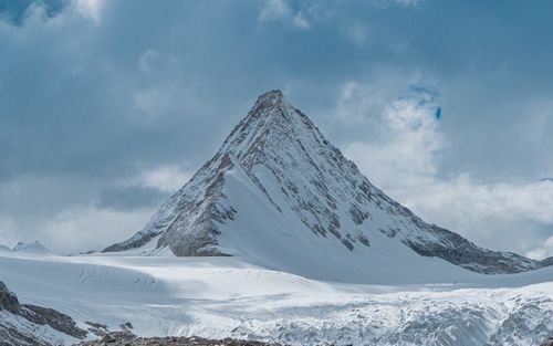 Free Stunning view of a snow-covered mountain peak in Tibet, under a dramatic cloudy sky. Stock Photo