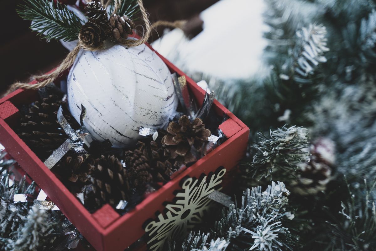 Snowy pinecones and greenery in a Christmas centerpiece box