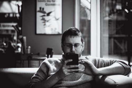 Uomo Che Tiene La Fotografia In Scala Di Grigi Del Telefono