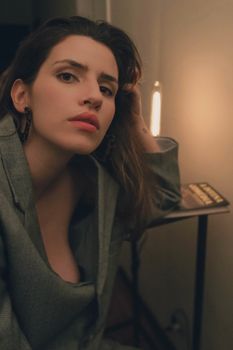 Portrait of a woman in a stylish gray blazer, exuding elegance and confidence indoors.