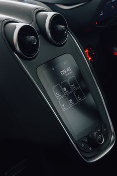 Close-up of a luxury car's high-tech dashboard with touchpad controls, showcasing modern automotive design.