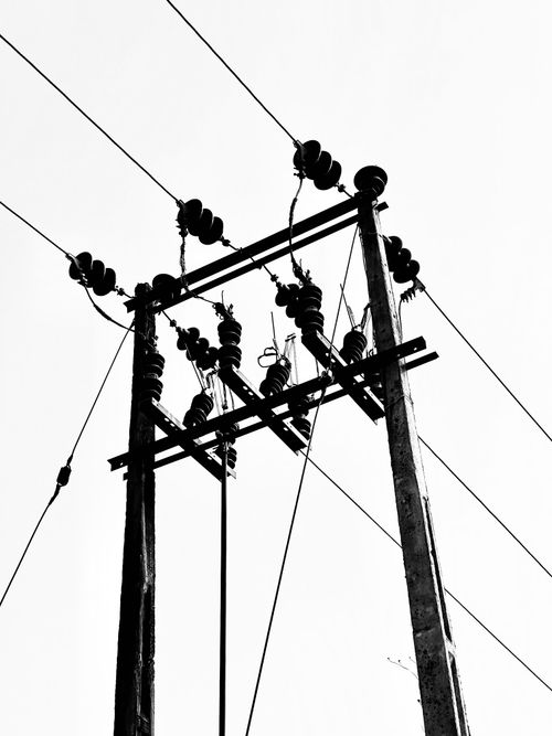 Free Monochrome low-angle shot of utility poles and power lines against a clear sky. Stock Photo