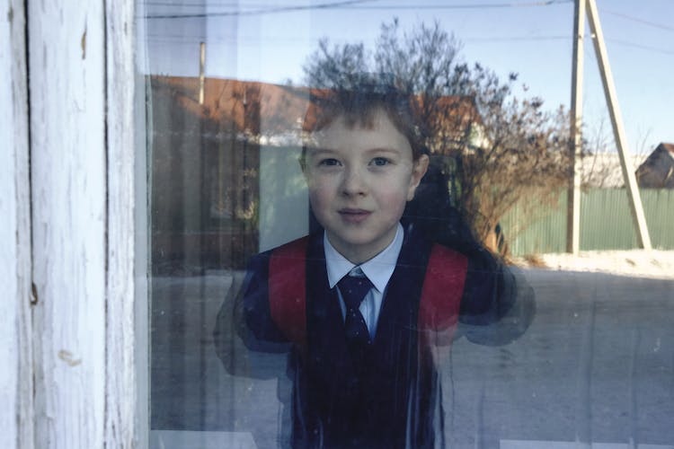 A Boy Looking At The Window