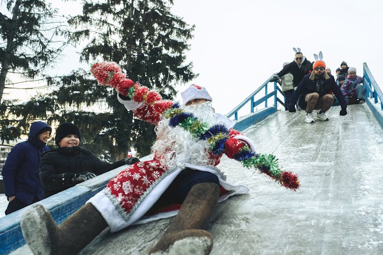 People And Santa Claus Sliding On Slide