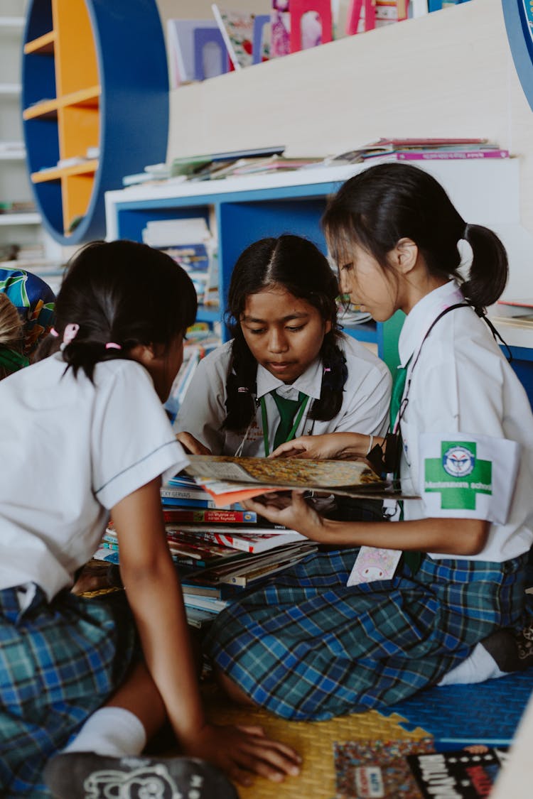 Thai Girls In School Uniforms Sitting At Table Reading