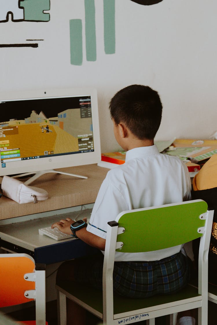 A Boy Playing Games On A Computer 