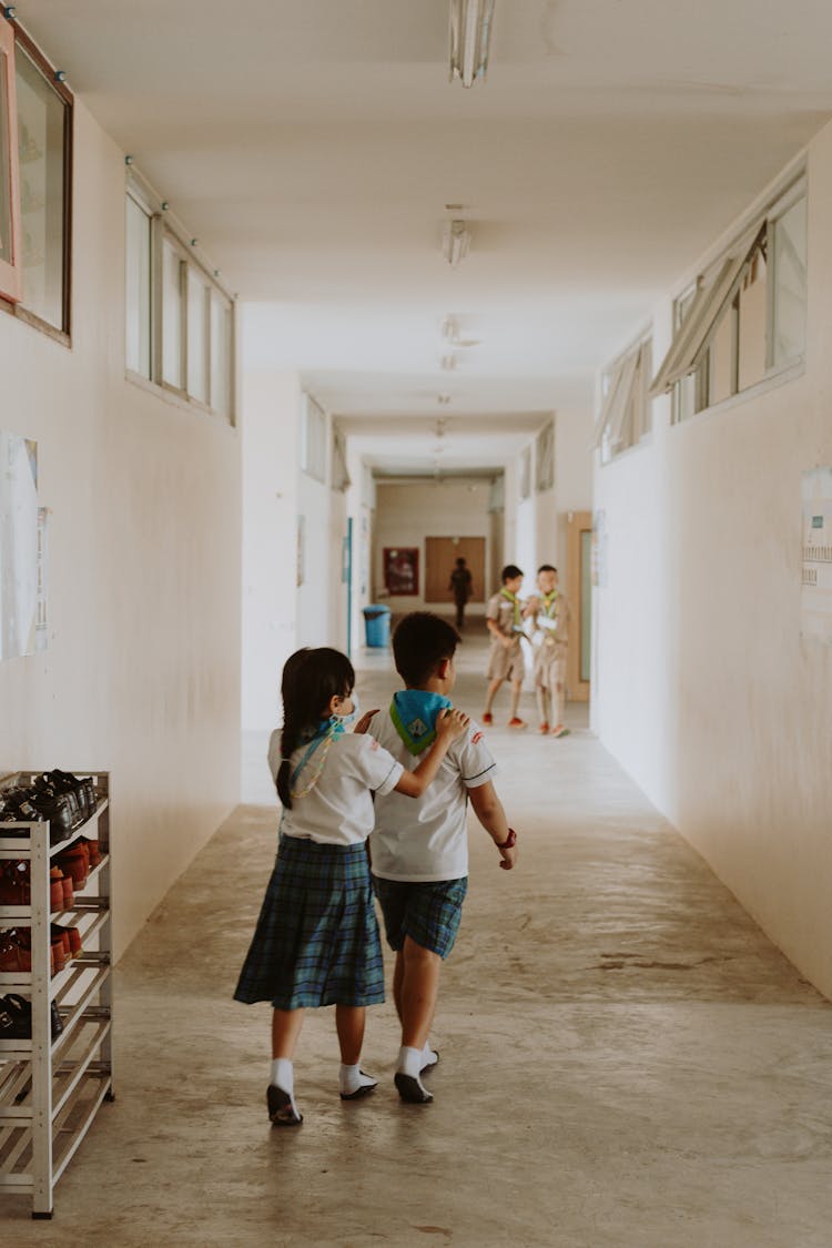 Children In School Uniforms Walking Through Hallway
