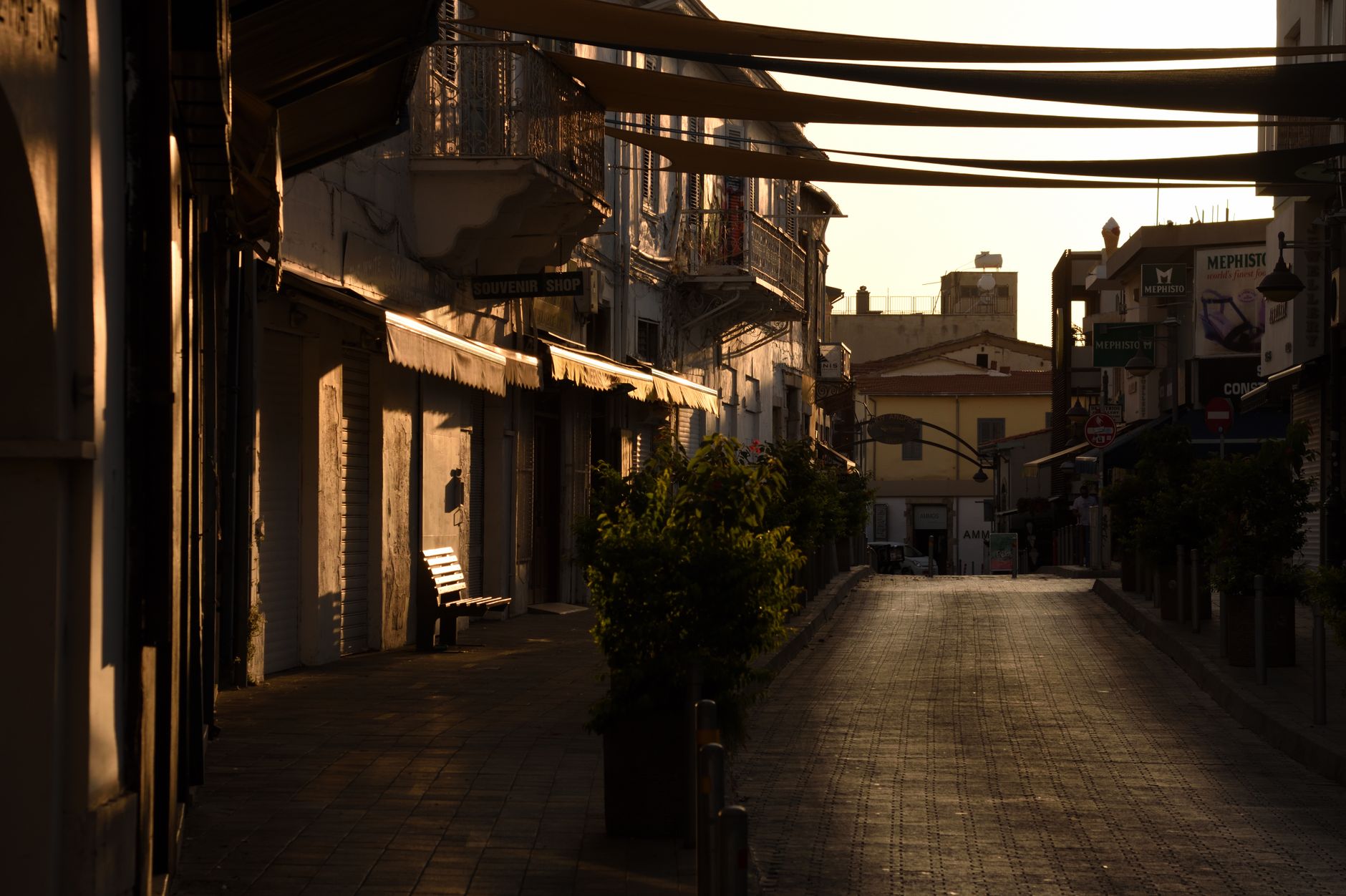 Wet cobbles and shuttered stone buildings in the old quarter of Limassol under grey sky
